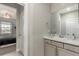 Bathroom with a basin sink, gray cabinets, neutral decor, and next to a bedroom with view of neighborhood at 5964 E 141St Ave, Thornton, CO 80602