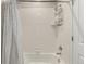 Clean bathroom with showerhead, white subway tile, and shower curtain with black and white stitching pattern at 5964 E 141St Ave, Thornton, CO 80602