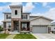 Charming home with a welcoming porch and stone detailing leading to a two-car garage at 5964 E 141St Ave, Thornton, CO 80602