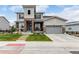Inviting two-story home featuring a well-manicured front yard and stone accents at 5964 E 141St Ave, Thornton, CO 80602