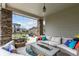 Covered patio area with stone columns, a modern gas fire pit, and comfortable seating at 5964 E 141St Ave, Thornton, CO 80602