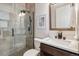 Modern bathroom featuring a glass shower with rain showerhead, sleek vanity, and decorative artwork at 1911 S Lafayette St, Denver, CO 80210