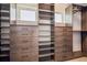 Walk-in closet with custom wood shelving, drawers, window and hanging space for clothing and storage at 1911 S Lafayette St, Denver, CO 80210