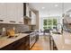 Modern kitchen boasts stainless appliances, bright white cabinets, with adjacent dining area at 1911 S Lafayette St, Denver, CO 80210