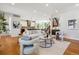 Bright, open-concept living room with hardwood floors, modern furniture, and staircase at 1911 S Lafayette St, Denver, CO 80210