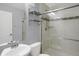 Bathroom features a sink, toilet, wall mirror, and walk-in shower with glass doors and chrome fixtures at 17938 E 54Th Ave, Denver, CO 80249