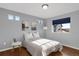 Bedroom features warm lighting, hardwood floors, and gray walls with ample sunlight from the windows at 17938 E 54Th Ave, Denver, CO 80249