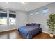 Cozy bedroom features hardwood floors, gray walls, natural light, and modern decor with simple bedside table at 17938 E 54Th Ave, Denver, CO 80249