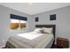 Bedroom features an upholstered headboard, bedside table, hardwood floors, and natural lighting at 17938 E 54Th Ave, Denver, CO 80249