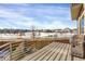 A well-maintained deck with a stainless steel gas grill that overlooks a snowy park area with a walking path and community at 17938 E 54Th Ave, Denver, CO 80249