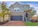 Charming two-story home with blue garage door, brick driveway and well-manicured landscaping at 17938 E 54Th Ave, Denver, CO 80249