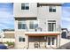Back exterior view of the house featuring a deck with stainless steel grill, patio, and neutral colored siding at 17938 E 54Th Ave, Denver, CO 80249