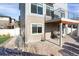 View of the rear of the home featuring an outdoor patio, upper deck, and neutral colored siding at 17938 E 54Th Ave, Denver, CO 80249