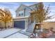 A delightful two-story home featuring a blue garage door, gray siding, and charming front entrance staircase at 17938 E 54Th Ave, Denver, CO 80249