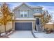 Attractive two-story home with a blue garage door, gray siding, and inviting front entrance staircase at 17938 E 54Th Ave, Denver, CO 80249