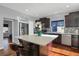 Well-lit kitchen featuring a center island with seating, stainless steel appliances and dark wood cabinets at 17938 E 54Th Ave, Denver, CO 80249