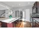Bright kitchen featuring a center island with seating, stainless steel appliances, and plenty of cabinet space at 17938 E 54Th Ave, Denver, CO 80249