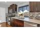 Updated kitchen featuring stainless steel appliances, modern backsplash, and a functional layout at 17938 E 54Th Ave, Denver, CO 80249