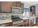 Modern kitchen with stainless steel appliances, updated backsplash, and plenty of counter space at 17938 E 54Th Ave, Denver, CO 80249