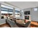 Spacious living room with fireplace, hardwood floors, and large windows offering abundant natural light and neighborhood views at 17938 E 54Th Ave, Denver, CO 80249
