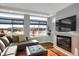 Inviting living room featuring a fireplace, hardwood floors, and large windows offering a bright and airy space at 17938 E 54Th Ave, Denver, CO 80249