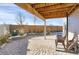 Brick paved patio underneath wood porch featuring a wind chime, outdoor seating, and a privacy fence at 17938 E 54Th Ave, Denver, CO 80249