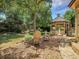 Landscaped backyard with mature tree, gazebo, and brick patio with seating creating an inviting outdoor space at 6005 S Jamaica Way, Englewood, CO 80111