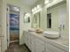 Well-lit bathroom featuring double sinks, white cabinets, and a shower/tub combo at 6005 S Jamaica Way, Englewood, CO 80111