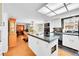 Bright kitchen features an island with cooktop, white cabinets, and stainless steel appliances at 6005 S Jamaica Way, Englewood, CO 80111