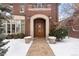 Charming brick home exterior with stone pathway leading to wooden front door and snow-covered landscaping at 425 Monroe St, Denver, CO 80206
