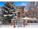 Inviting brick home with address number, iron gate, mature trees, and snow-covered landscaping at 425 Monroe St, Denver, CO 80206