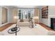 Bright living room featuring a large bay window, fireplace, custom bookshelf, and hardwood floors at 425 Monroe St, Denver, CO 80206