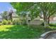 Lush green backyard with manicured lawn and mature trees creating a private oasis at 7183 S Poplar St, Centennial, CO 80112