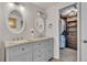 Bathroom vanity area with double sinks, granite countertop and mirrors with view into the walk-in closet at 7183 S Poplar St, Centennial, CO 80112