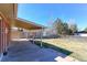 Relaxing covered patio with a spacious backyard featuring lush grass, mature trees, and a well-maintained fence at 383 S 21St Ave, Brighton, CO 80601
