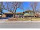 Charming home boasts a well-manicured lawn, mature trees, and a two-car garage at 383 S 21St Ave, Brighton, CO 80601