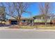 Charming home boasts a well-manicured lawn, mature trees, and a two-car garage at 383 S 21St Ave, Brighton, CO 80601