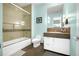 Stylish bathroom featuring a tub with glass doors, modern vanity, and blue walls at 1250 Dolan Dr, Monument, CO 80132