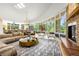 Open-concept living room with floor-to-ceiling windows and a stone fireplace at 1250 Dolan Dr, Monument, CO 80132
