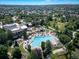 Aerial view of a community pool, clubhouse, and surrounding residential area with lush landscaping at 8626 Gold Peak Dr # B, Highlands Ranch, CO 80130