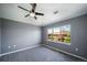 Cozy bedroom with neutral walls, carpet, a ceiling fan and large window showcasing neighborhood views at 8626 Gold Peak Dr # B, Highlands Ranch, CO 80130