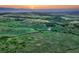 An expansive aerial view reveals rolling grassy plains and a serene horizon at sunset at 12350 Turquoise Terrace St, Castle Pines, CO 80108