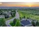An aerial view of a suburban neighborhood with a view of the plains and mountains at sunset at 12350 Turquoise Terrace St, Castle Pines, CO 80108