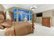 A bedroom with a large window, brown furniture and a television mounted to the wall at 12350 Turquoise Terrace St, Castle Pines, CO 80108