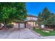 Charming two-story home with a stone facade, three-car garage, and well-maintained front yard with mature trees at 12350 Turquoise Terrace St, Castle Pines, CO 80108