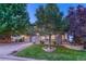 Beautiful two-story home with stone accents, mature trees, and a well-manicured lawn at 12350 Turquoise Terrace St, Castle Pines, CO 80108