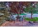 Cozy front yard seating area with two chairs and a small table beneath a mature tree at 12350 Turquoise Terrace St, Castle Pines, CO 80108