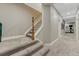 Hallway with carpet stairs, gray walls, and white trim leads into a spacious carpeted rec room with gym equipment at 12350 Turquoise Terrace St, Castle Pines, CO 80108