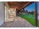 A covered patio area leads to a grassy backyard with stone landscaping and a partially exposed under-deck at 12350 Turquoise Terrace St, Castle Pines, CO 80108