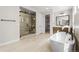 Elegant bathroom with soaking tub, glass shower, and modern vanity with ample counter space at 6529 Still Pine Cir, Castle Pines, CO 80108